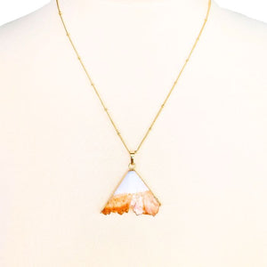 Gold triangle pendant necklace featuring a unique orange and white stone design.