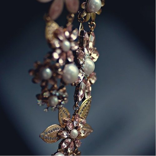 Elegant floral earrings featuring pink crystals and pearls.