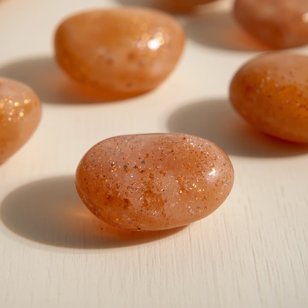 Polished orange and golden sunstone showing metallic copper shimmer