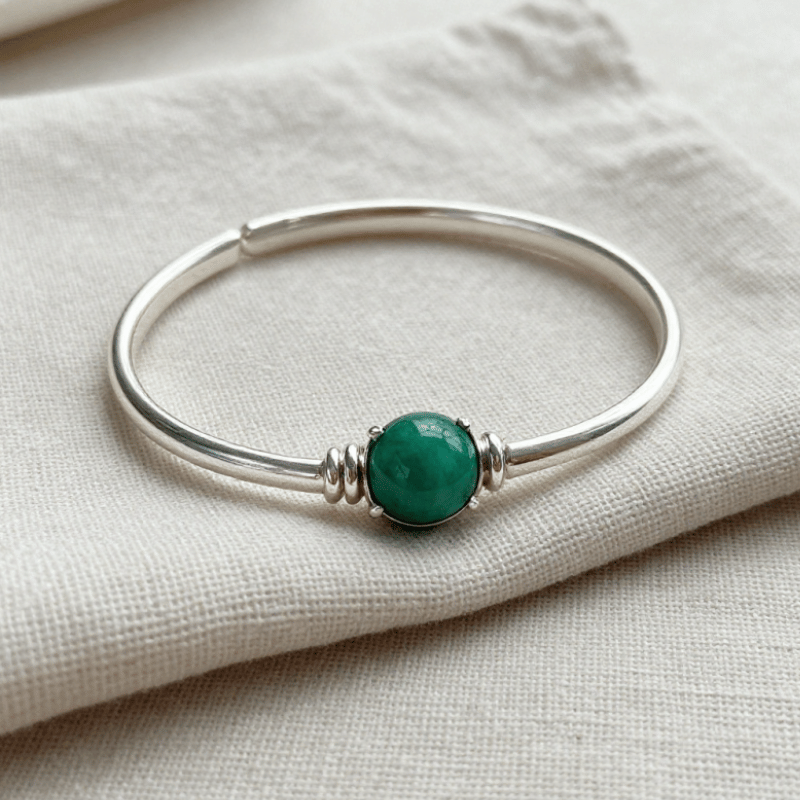 Cleaning a sterling silver gemstone bracelet with a soft microfibre cloth.